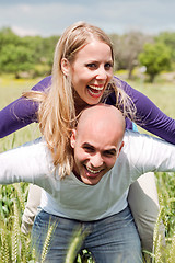 Image showing Happy cute woman being piggy backed by her boyfriend