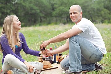 Image showing Couple sitting in blanket smiling with picnic mode