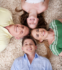 Image showing Happy family lying  with their heads close together smiling