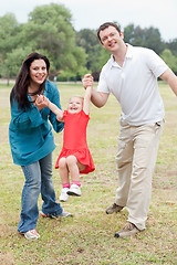 Image showing Lovely couples playing with their happy daughter at the park