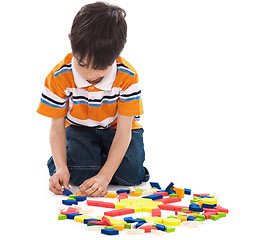 Image showing Adorable caucasian boy joining the blocks while playing