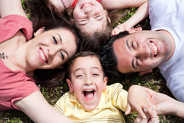 Image showing Parents and kids laying on the floor with heads together