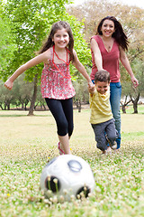 Image showing Childrens playing football with their mother
