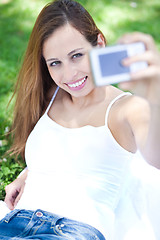 Image showing Smiling young woman taking self portrait