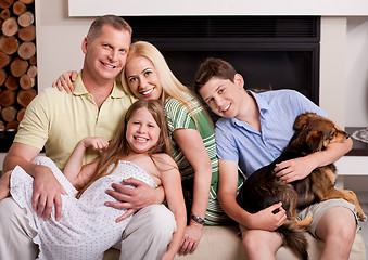 Image showing Happy domestic family sitting in living room with dog