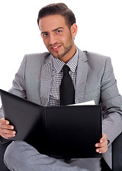 Image showing Young business man holding a clip board