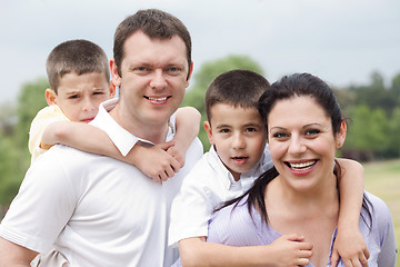 Image showing Beautiful couple carrying their kids on their back