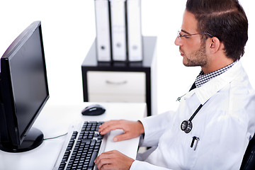 Image showing male doctor working with desktop at his desk