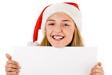Image showing Women with santa cap smiling and holding a blank board