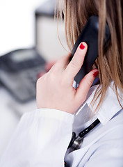 Image showing Back shot of a female doctor over a phone call