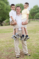 Image showing father carrying his two son in his hands