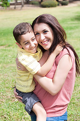 Image showing Cute kid with white dress sitting on her mom