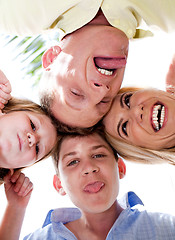 Image showing Joyful family making weird faces in huddle