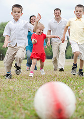 Image showing Beautiful family of five on outdoors running towards the foot ball