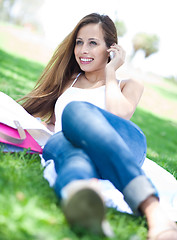 Image showing Young women lying in park using mobile phone