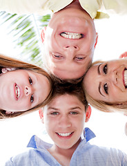 Image showing Happy family smiling and joining their heads together