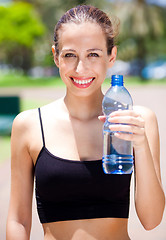 Image showing Smiling fitness woman with water bottle