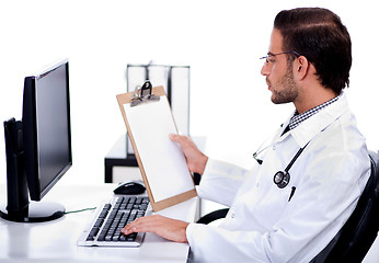 Image showing Young ethnic doctor looking at medical report deeply