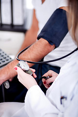 Image showing Female doctor checking blood pressure