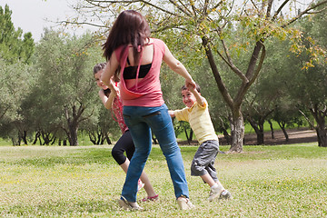 Image showing Back shot of a family of three playing