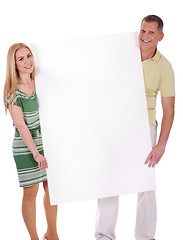 Image showing Middle aged smiling couple holding a blank white board