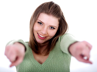 Image showing Smiling young female pointing through her both hands