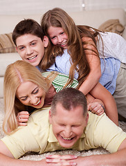 Image showing Happy family of four having fun in bed