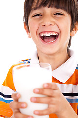 Image showing Smiling young boy holding a glass of milk