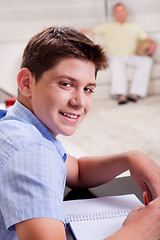 Image showing Young boy in focus, studying and smiling at camera