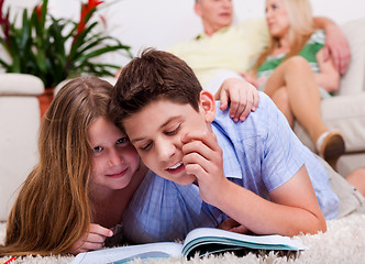 Image showing Kids studying with family in the background