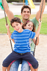 Image showing Father and children enjoying swing ride