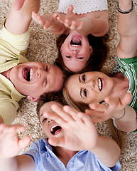 Image showing Happy family of four lying on the carpet