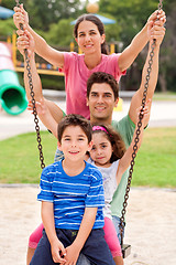 Image showing Jolly caucasian family swinging in the park