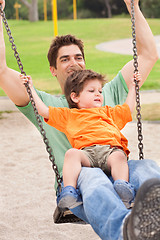 Image showing Father enjoying swing ride with his son