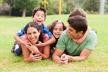 Image showing Playful family lying outdoors and smiling