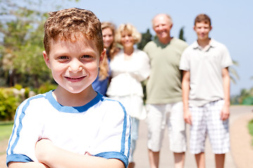 Image showing Young cute boy in focus with family in the background