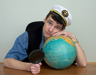 Image showing Guy in a sea cap with a globe