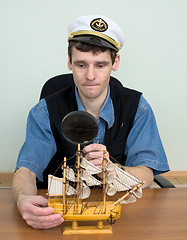 Image showing Guy in a sea cap with toy sailing vessel