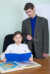 Image showing Tutor and schoolgirl with book and atlas