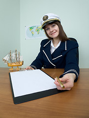 Image showing Woman in a sea uniform at table with tablet