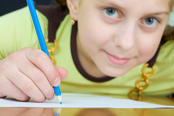 Image showing Girl holding a blue pencil