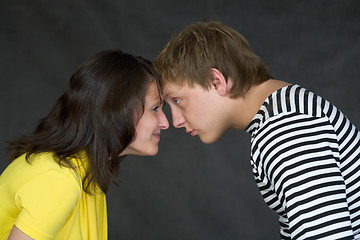 Image showing Guy and the girl have faced foreheads on a black