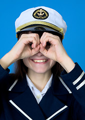 Image showing Funny girl in a sea uniform emits binoculars