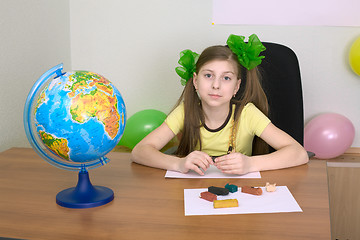 Image showing Girl sitting at a table with plasticine