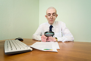 Image showing Boss with a magnifier on a workplace