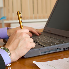 Image showing Laptop and hands with a pen