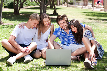 Image showing Friends enjoying movie in park on laptop