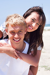 Image showing Girl riding on guy at beach