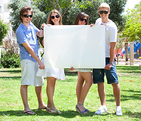 Image showing Teens with white billboard standing in park