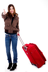 Image showing young female traveller showing thumbs-up